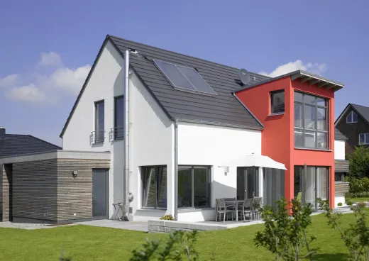 Einfamilienhaus in Löhne: Satteldachhaus mit rotem Erker und Holzanbau