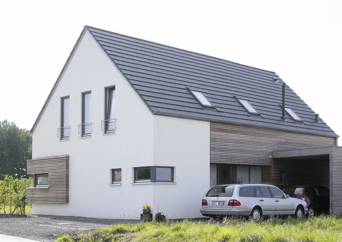 Einfamilienhaus in Löhne: Weißes Satteldachhaus mit Holzverkleidung und Carport