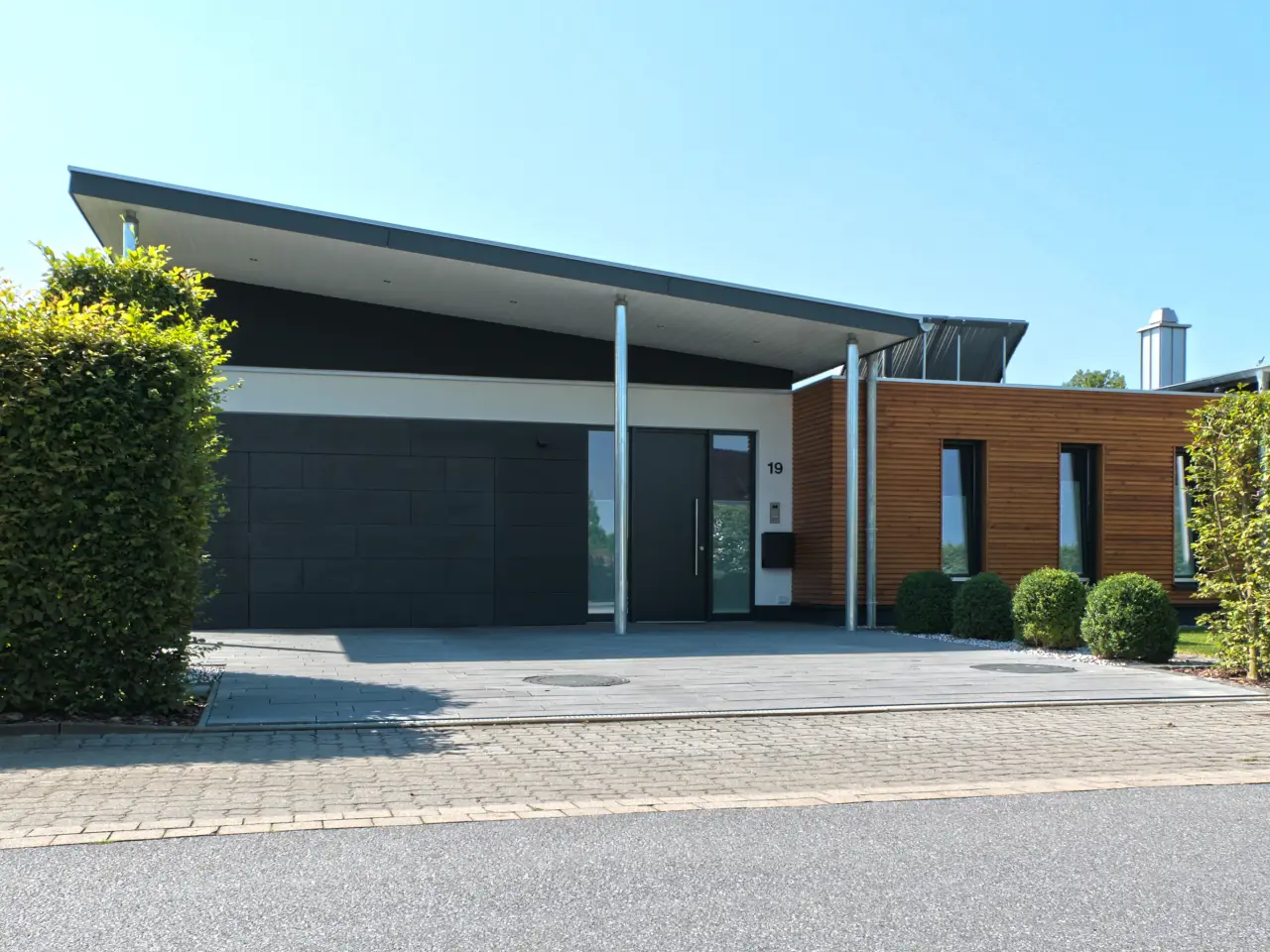 Einfamilienhaus in Löhne: Flachdachbau mit Holzfassade und Garage