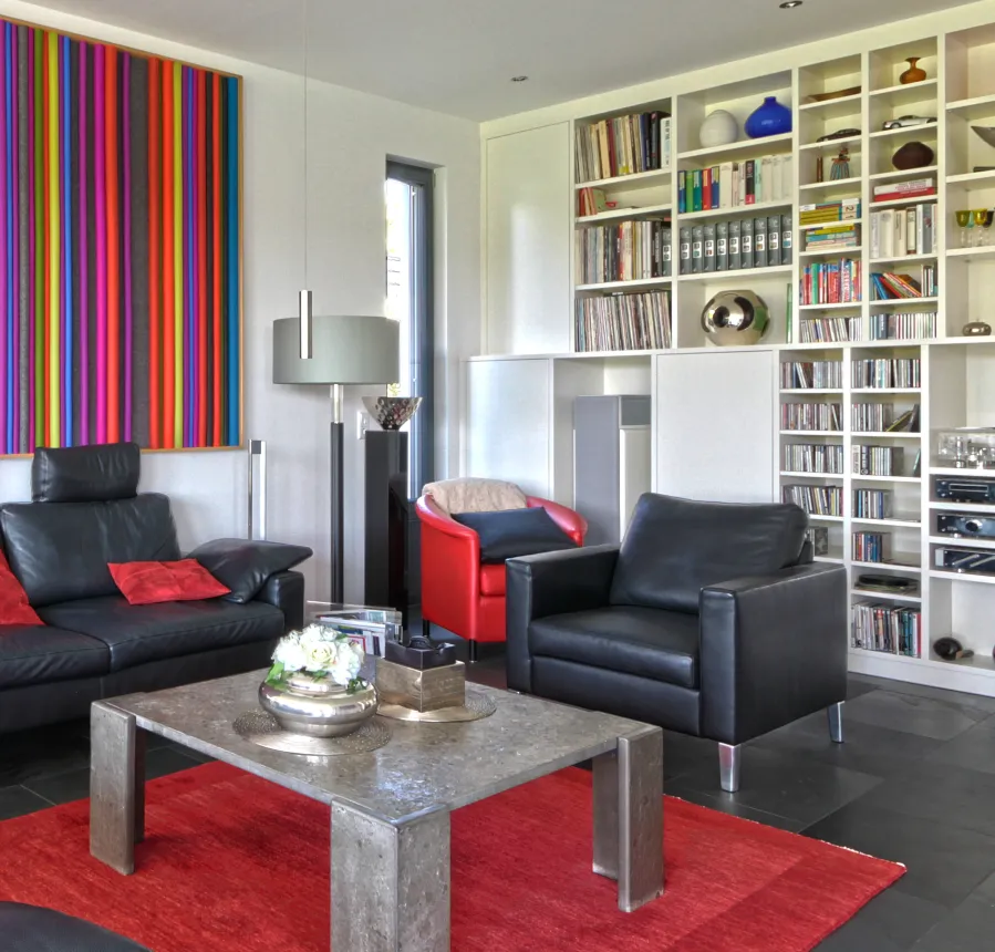 Einfamilienhaus in Löhne: Wohnzimmer mit Ledersofas und Bücherregal