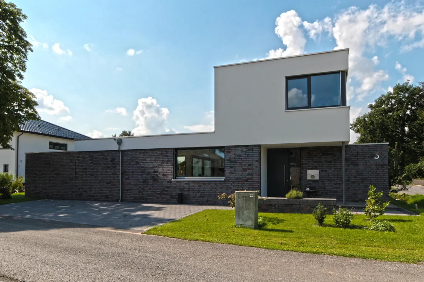 Einfamilienhaus in Löhne: Flachdachhaus mit Klinkersockel an der Straße