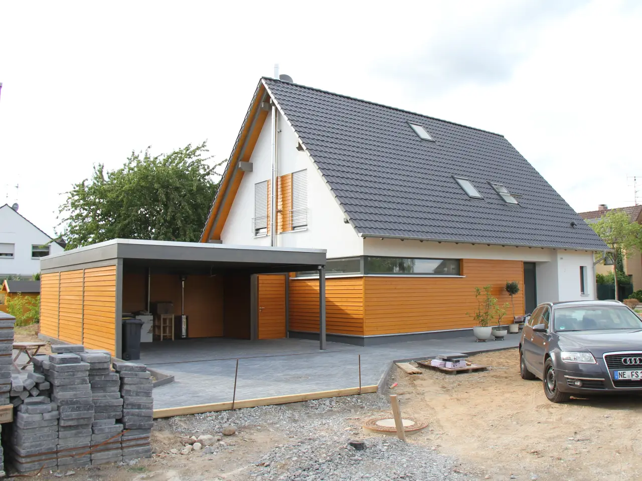 Einfamilienhaus in Meerbusch: Satteldachhaus mit Holzelementen und Carport im Bau