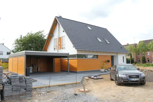 Einfamilienhaus in Meerbusch: Satteldachhaus mit Holzelementen und Carport im Bau