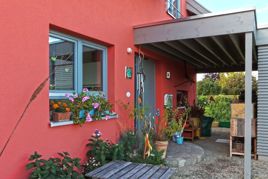 Einfamilienhaus in Minden: Eingang mit Vordach an roter Fassade