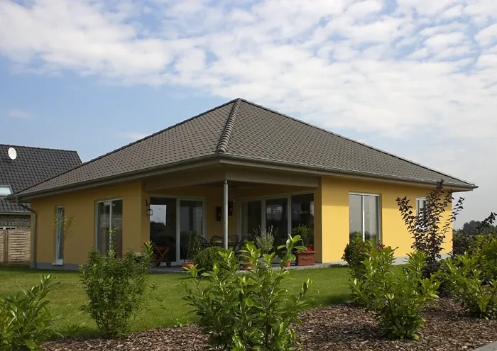 Einfamilienhaus in Minden: Gelber Bungalow mit Walmdach im Garten