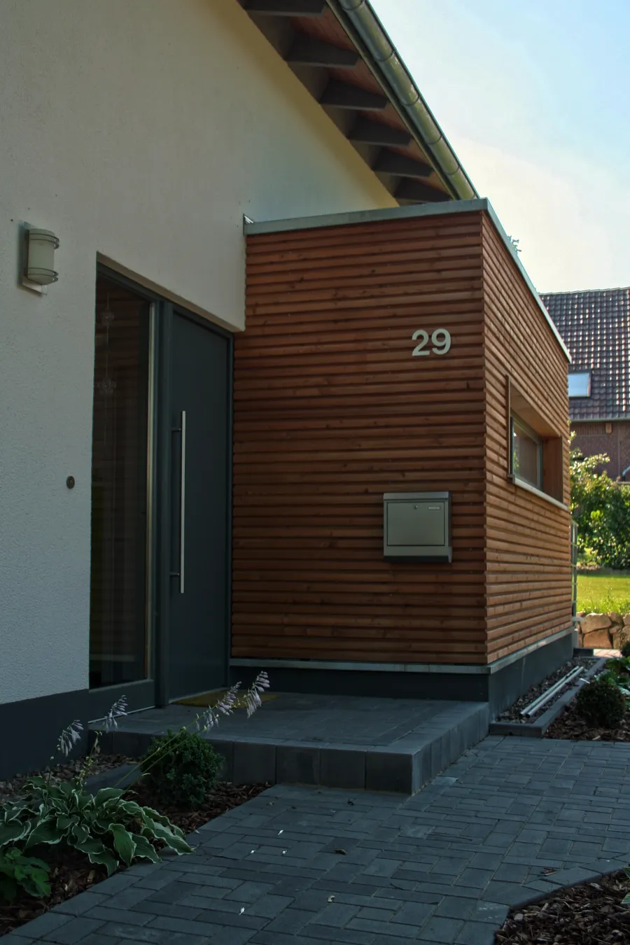 Einfamilienhaus in Minden: Holzverkleidung mit Hausnummer am Eingang