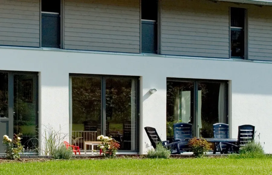 Einfamilienhaus in Minden: Terrasse mit Gartenmöbeln vor großen Fenstern