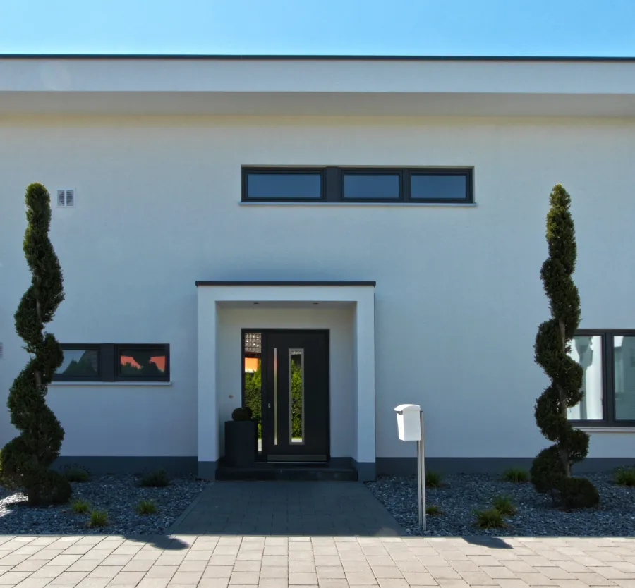 Einfamilienhaus mit Einliegerwohnung in Bad Oeynhausen: Hauseingang mit Vordach und Formbäumen