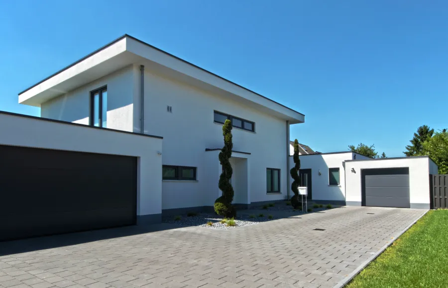 Einfamilienhaus mit Einliegerwohnung in Bad Oeynhausen: Wohnhaus mit flachem Walmdach und Doppelgarage