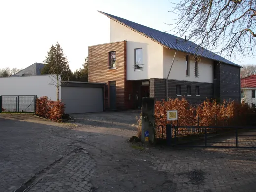 Einfamilienhaus mit Einliegerwohnung in Bad Oeynhausen: Wohnhaus mit Pultdach und Holzfassade am Abend