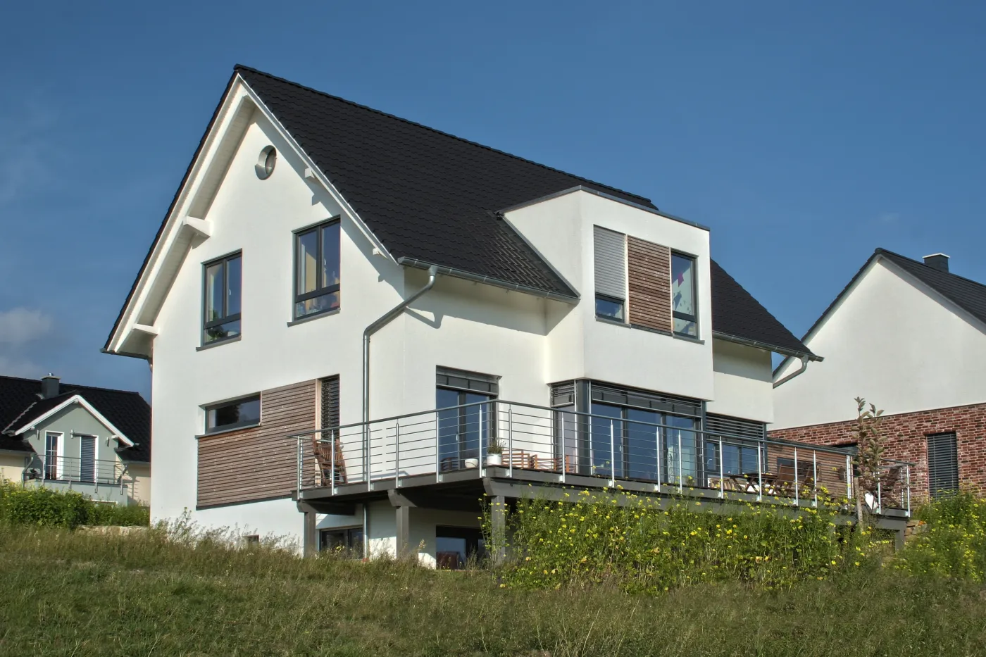 Einfamilienhaus in Oerlinghausen: Satteldachhaus mit Holzband und umlaufendem Balkon