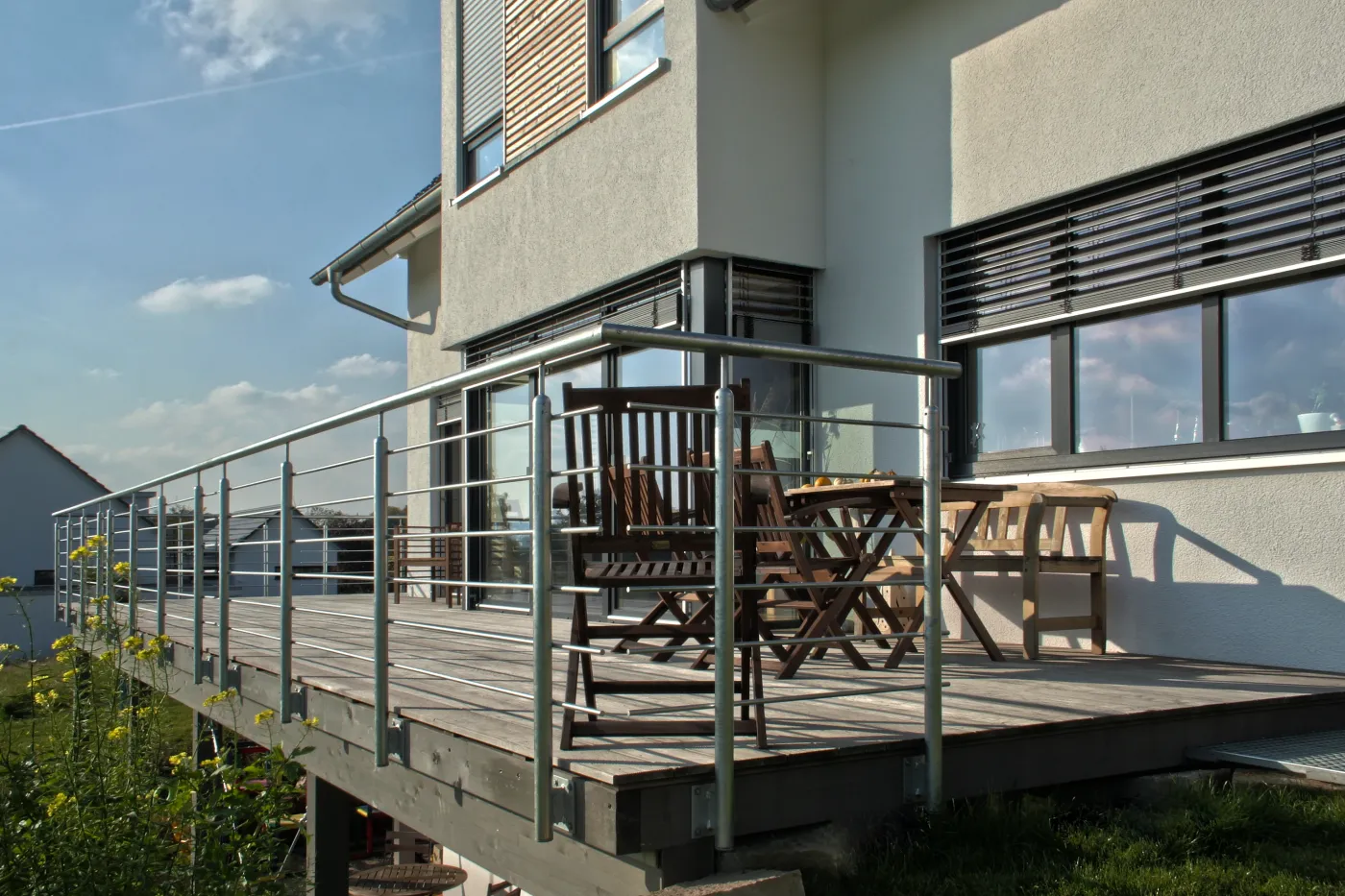 Einfamilienhaus in Oerlinghausen: Holzbalkon mit Edelstahlgeländer und Gartenmöbeln