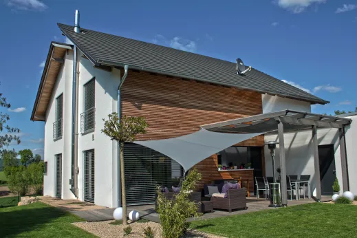 Einfamilienhaus in Porta Westfalica: Satteldachhaus mit Holzfassade und Sonnensegel
