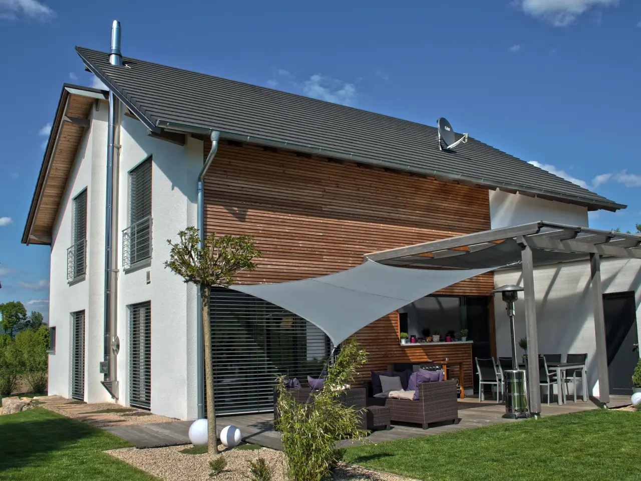 Einfamilienhaus in Porta Westfalica: Satteldachhaus mit Holzfassade und Sonnensegel