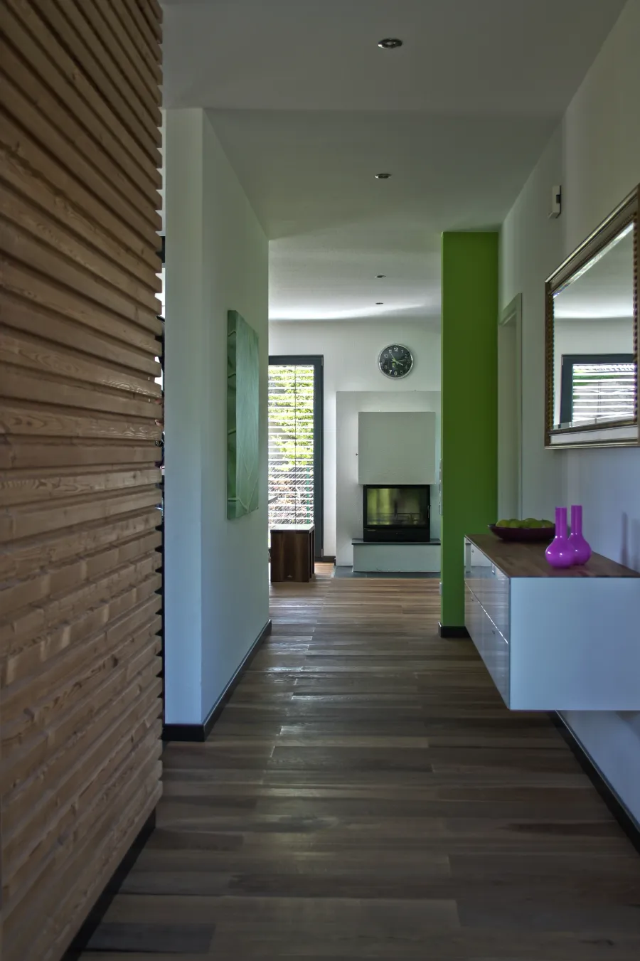 Einfamilienhaus in Porta Westfalica: Flur mit Holzwand und dunklem Boden