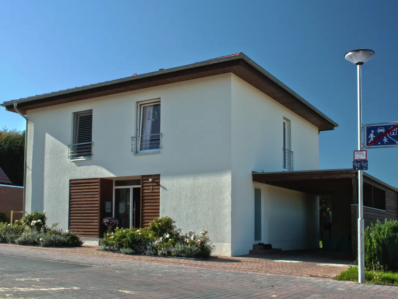 Einfamilienhaus in Werther: Wohnhaus mit flachem Walmdach und Carport