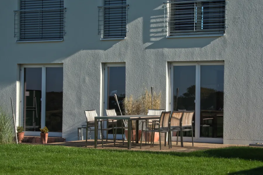 Einfamilienhaus in Werther: Terrasse mit Essplatz vor großen Fenstern