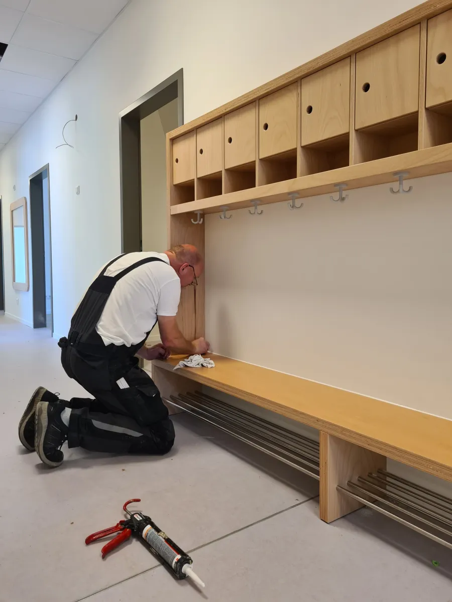 Kita-Erweiterung in Löhne-Gohfeld: Handwerker montiert eine Garderobe in der Kita