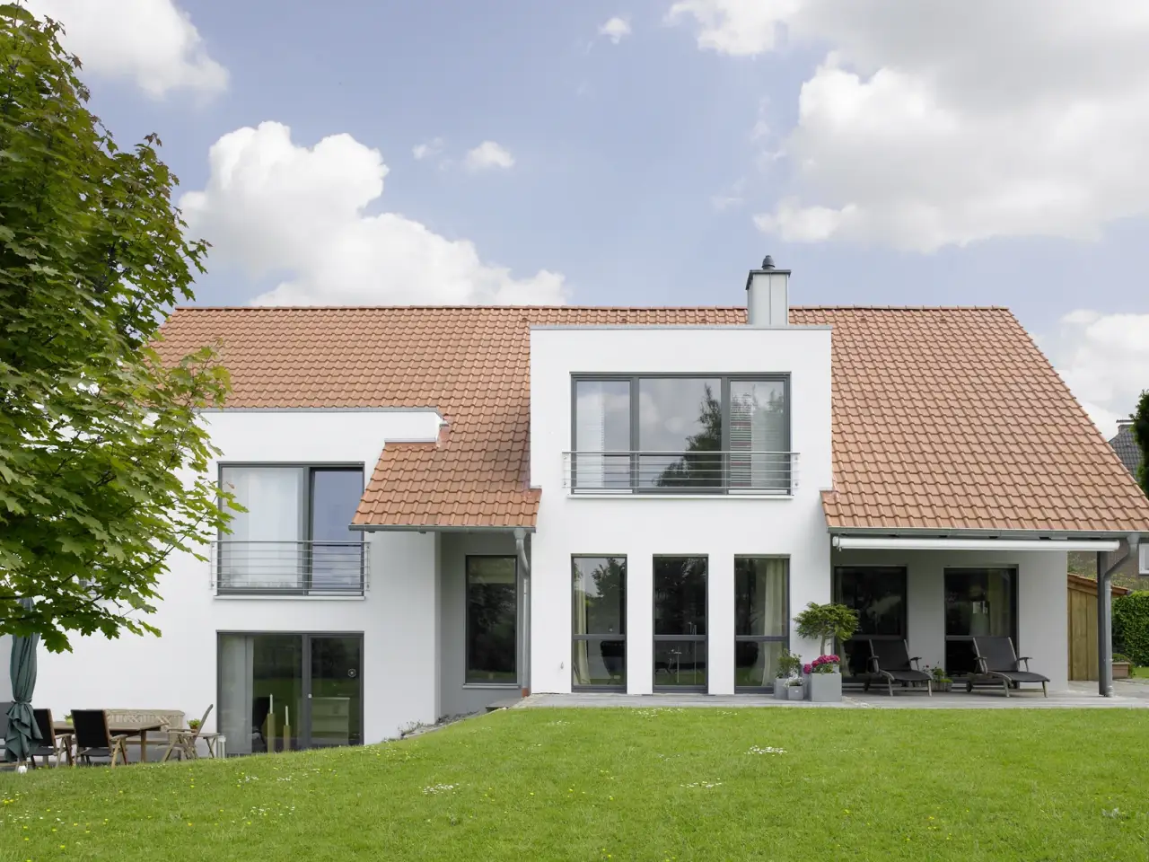 Einfamilienhaus in Howacht: Wohnhaus mit roter Dacheindeckung und Garten