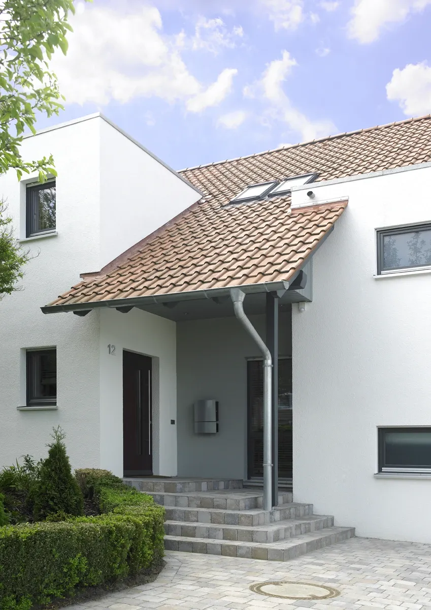 Einfamilienhaus in Howacht: Hauseingang mit Vordach und Treppe