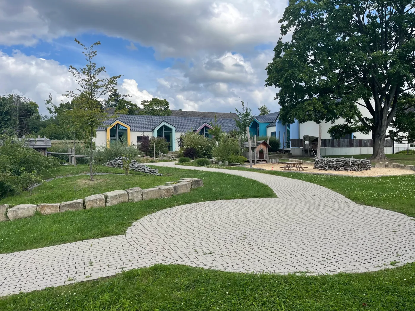 Kita in Holzrahmenbauweise in Herford: Außengelände mit Wegen vor der Kita
