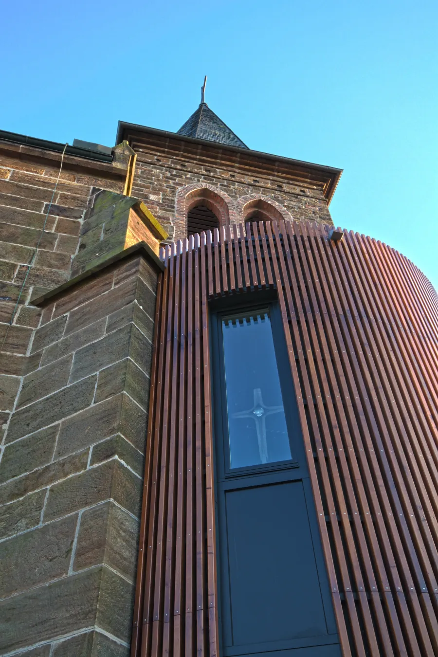 Kirche in Bad Oeynhausen: Holzanbau mit schmalem Fenster am Kirchturm