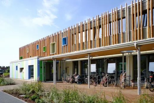 Kita-Neubau in Hameln: Kita mit vertikaler Holzlamellenfassade und farbigen Fensterrahmen