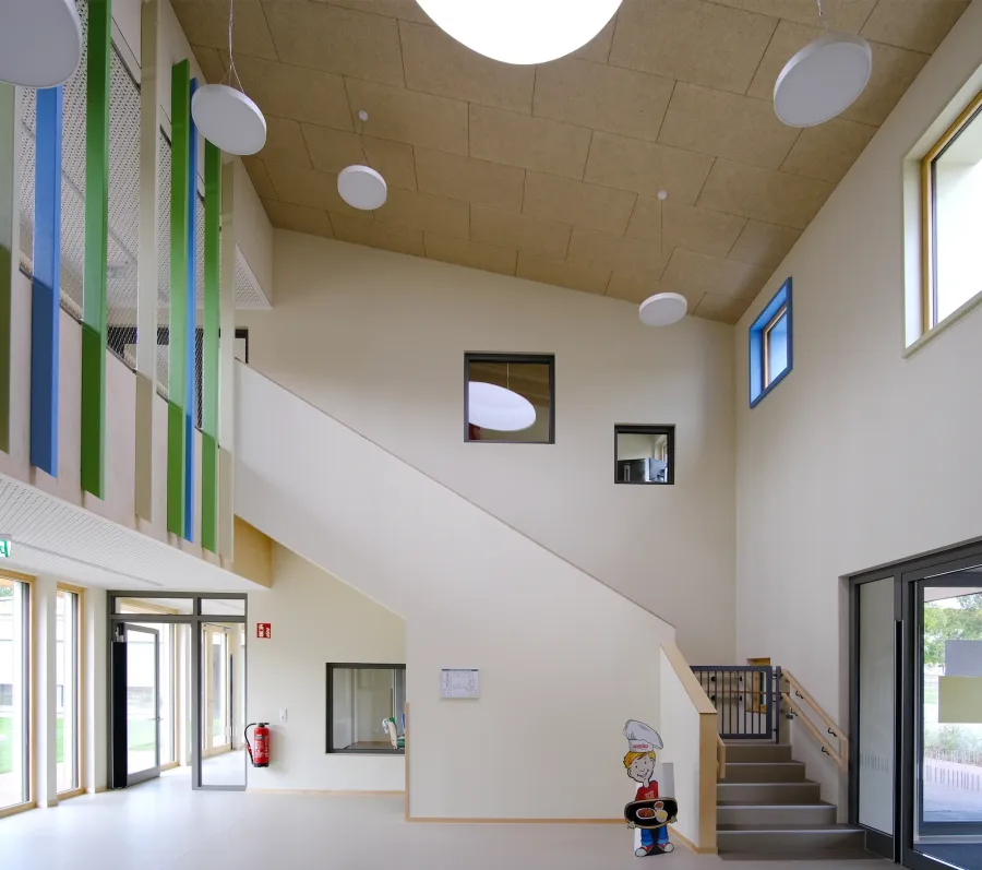 Kita-Neubau in Hameln: Luftraum mit Treppe und Holzdecke in der Kita