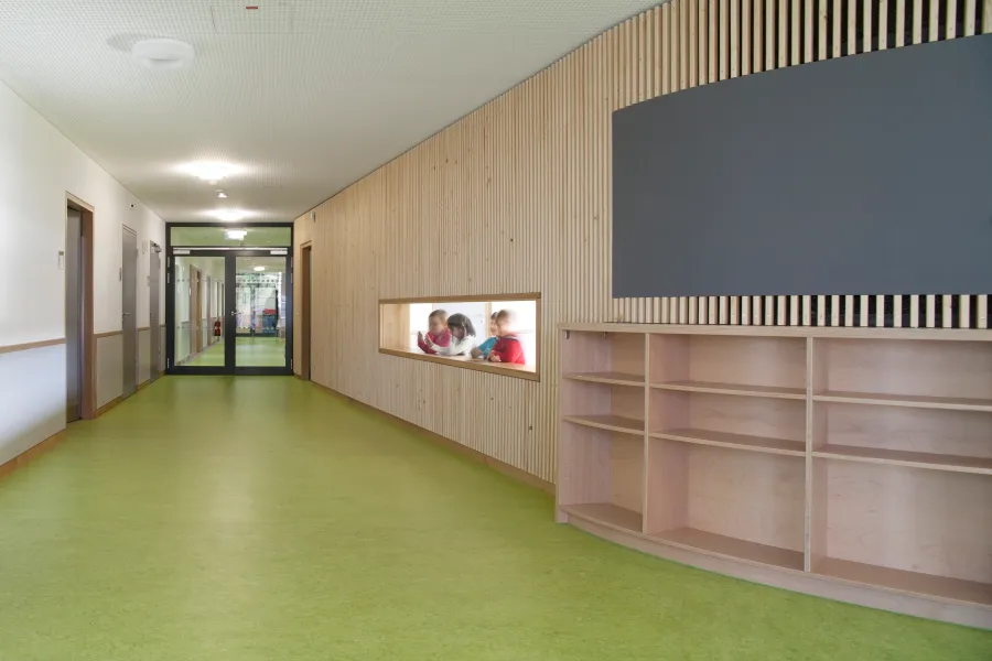 Kita in Holzrahmenbauweise in Hannover: Kita-Flur mit Holzwand und Regal