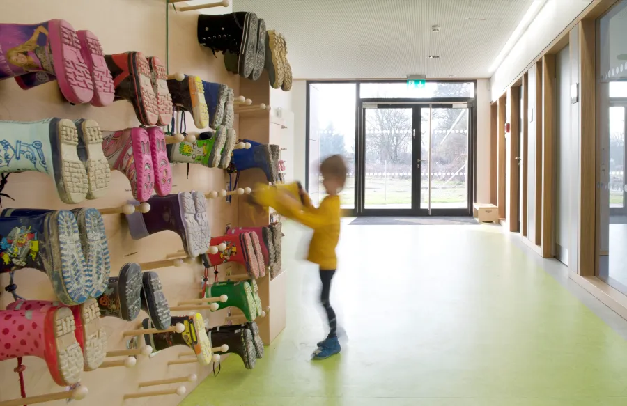 Kita in Holzrahmenbauweise in Hannover: Kind an der Garderobe im Flur