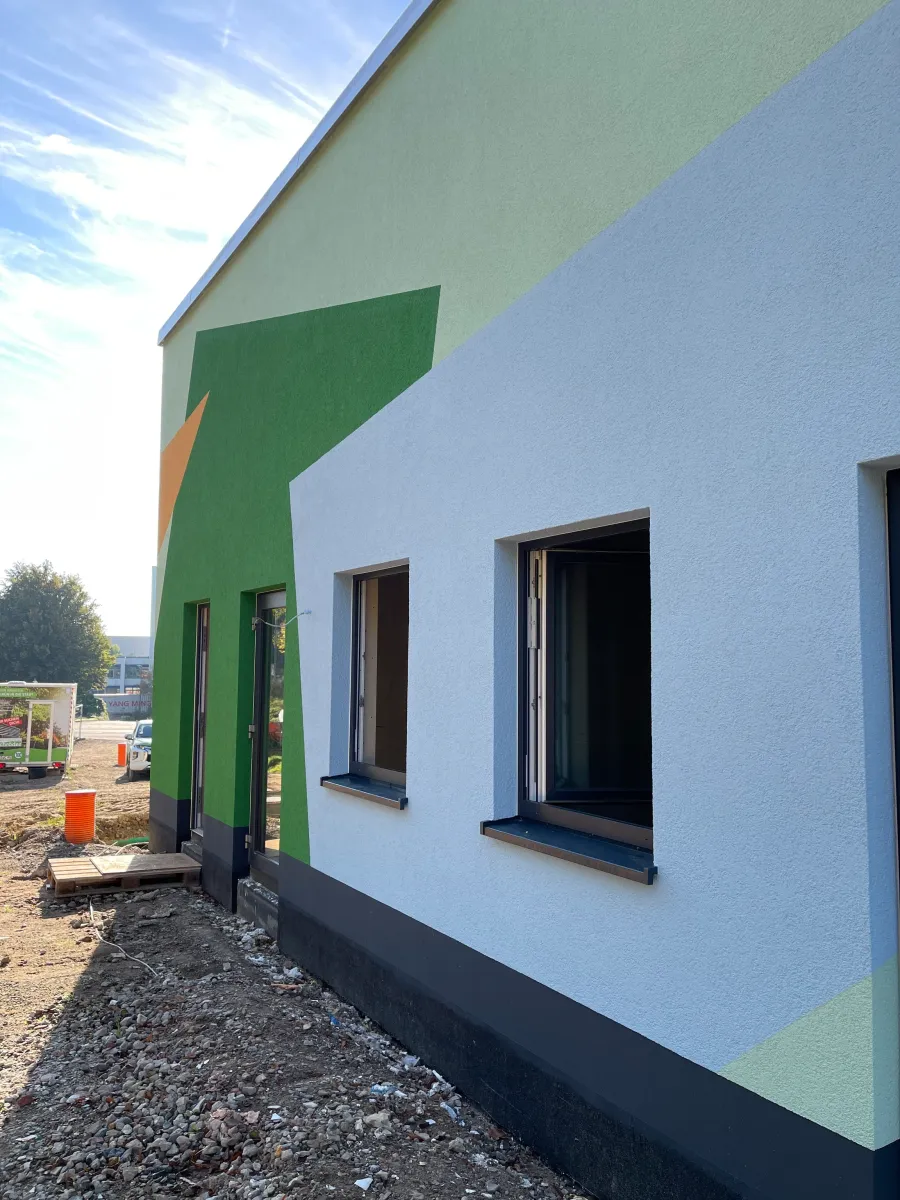 Kita mit Quartierstreff in Herford: Fassade mit farbigen Flächen und Fenstern