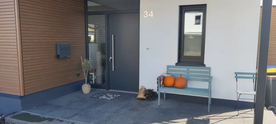 Wohnhaus in Sendenhorst: Hauseingang mit Holzverkleidung und Bank