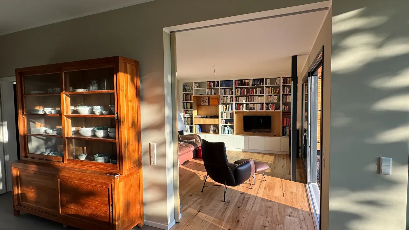 Portrait Zuhause in der Obstwiese: Wohnraum mit altem Buffetschrank und Blick ins Wohnzimmer
