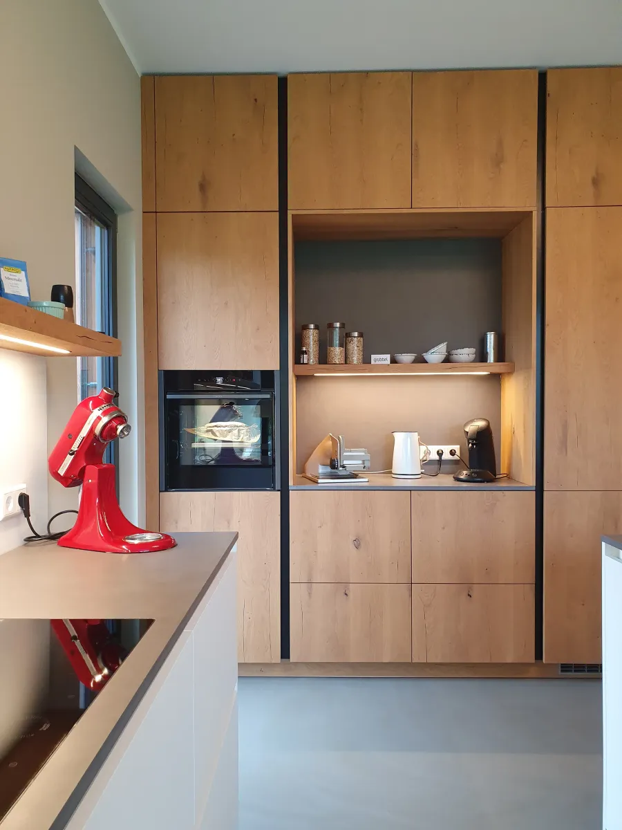 Portrait Zuhause in der Obstwiese: Küchenwand aus Holz mit Backofen und Nischenregal