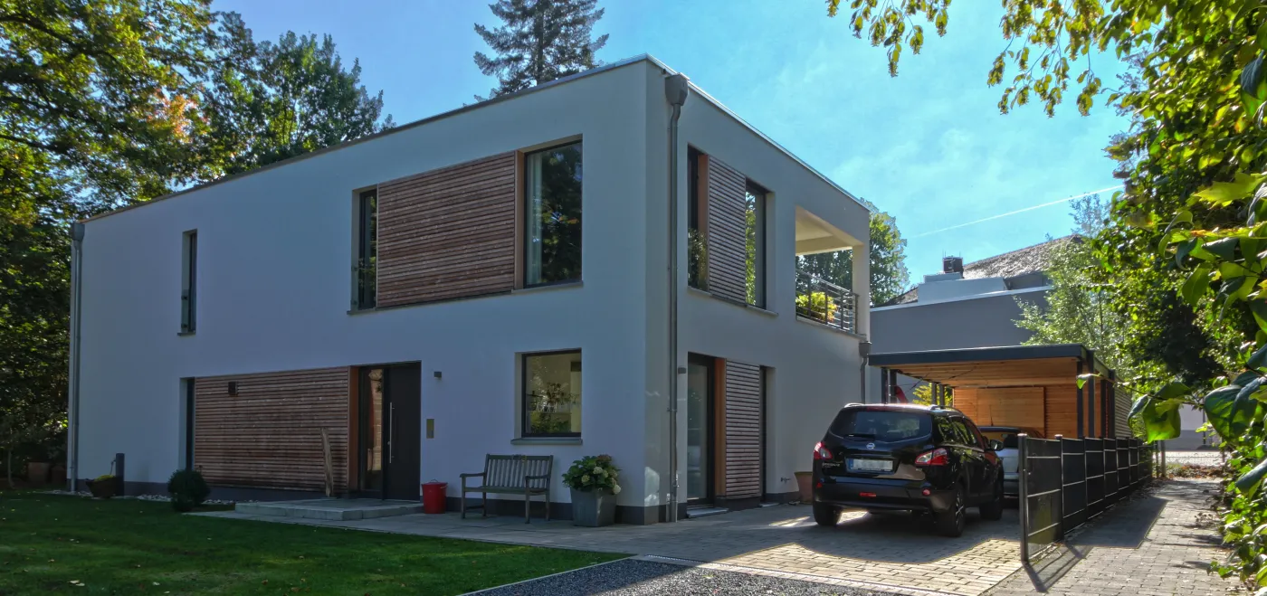 Zweifamilienhaus in Bünde: Zweifamilienhaus mit Holzfassadenelementen und Carport